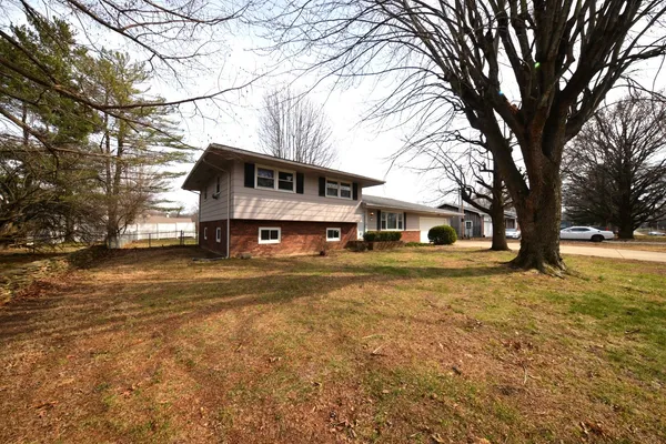 a front view of a house with a yard covered with snow