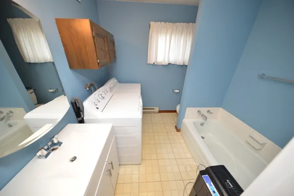 a bathroom with a bathtub sink and mirror