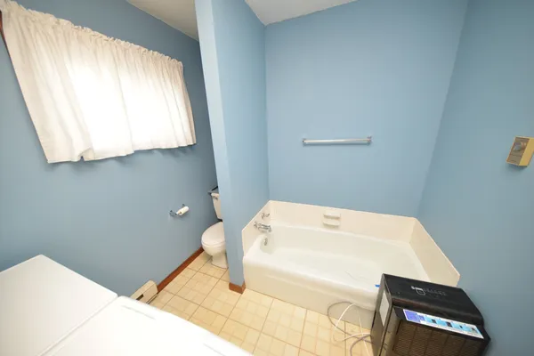 a bathroom with a bathtub and a window