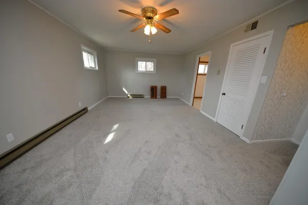 a view of empty room with window and ceiling fan