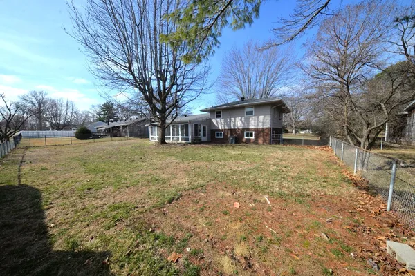 a view of a yard with a house and large trees