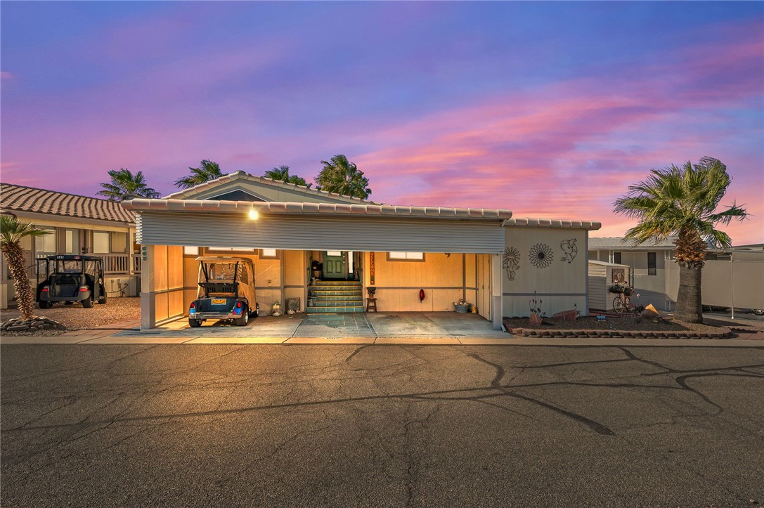 Resort-style curb appeal at golden hour. Pride of ownership shines with clean lines, covered parking, and a welcoming, low-maintenance exterior.