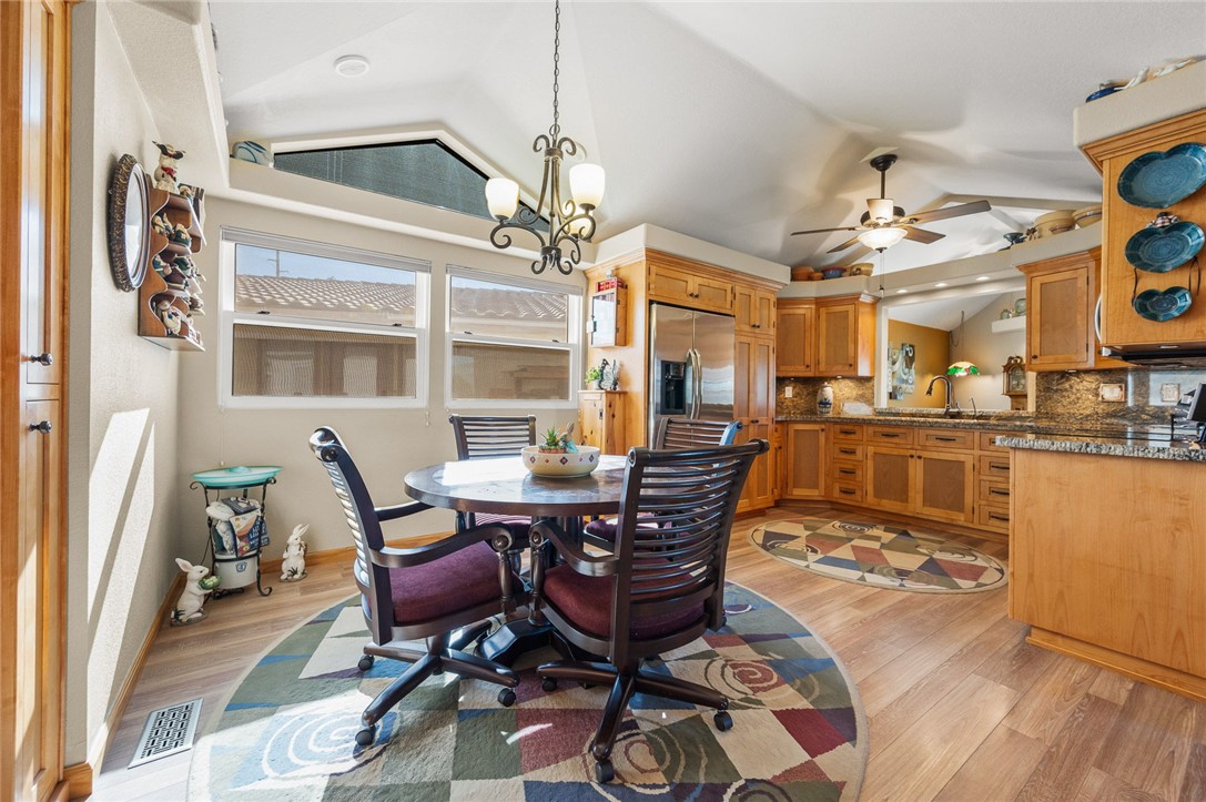 2000 Ramar Road, Unit 665 Bullhead City, AZ 86442 - Photo 21 of 83 Open kitchen and dining layout highlighting custom cabinetry, granite countertops, skylight, stainless appliances, and excellent storage throughout.