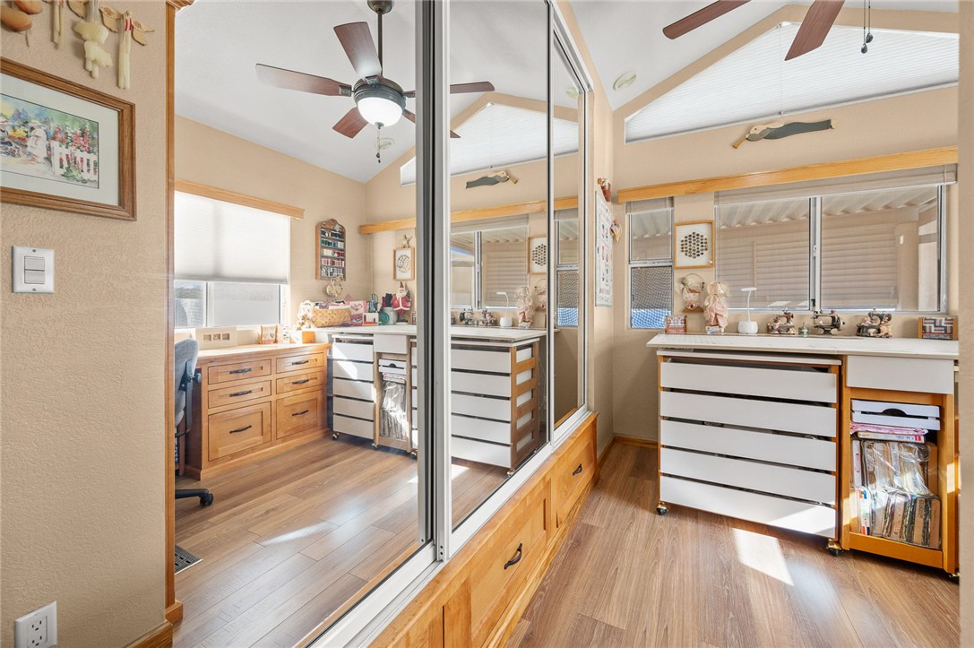 2000 Ramar Road, Unit 665 Bullhead City, AZ 86442 - Photo 25 of 83 Flexible room with built-in cabinetry, luxury hard surface flooring, vaulted ceiling, and ceiling fan; currently used as a craft/workspace, with freestanding furniture that is removable.