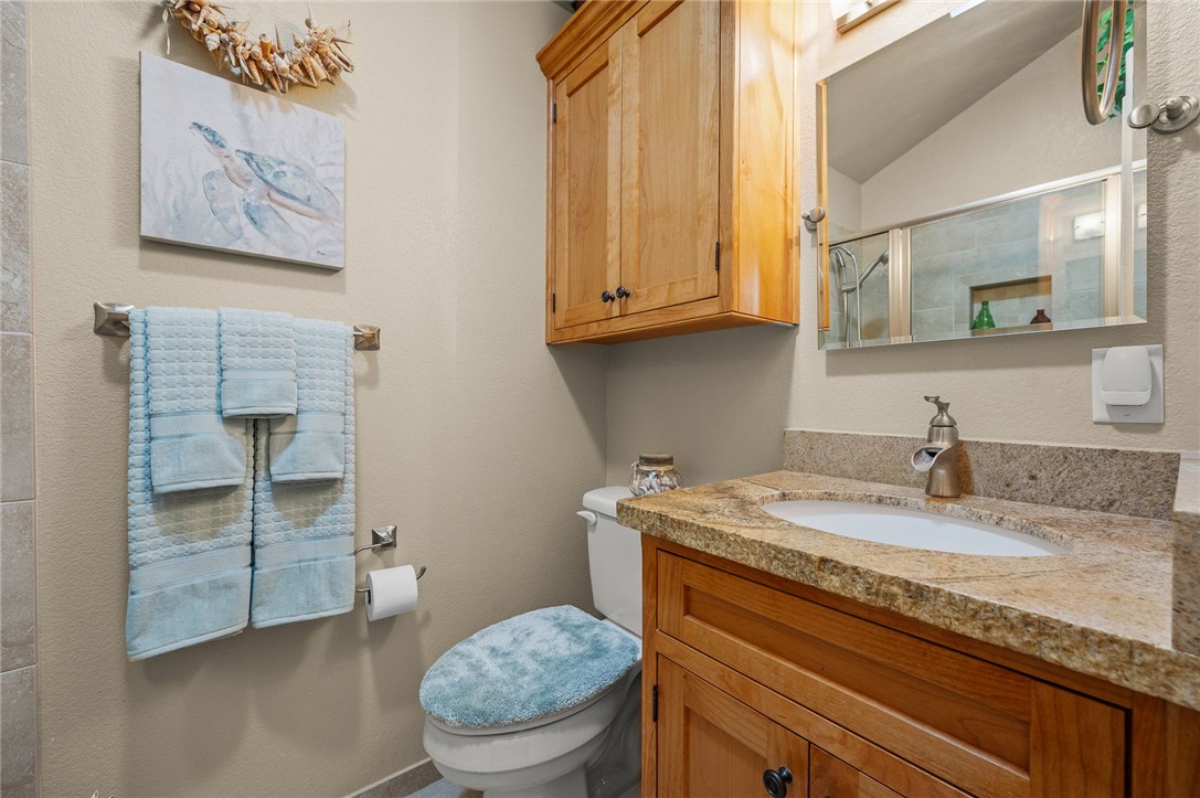 2000 Ramar Road, Unit 665 Bullhead City, AZ 86442 - Photo 27 of 83 Bathroom with granite countertop, undermount sink, wood vanity cabinetry, and upper storage cabinet.