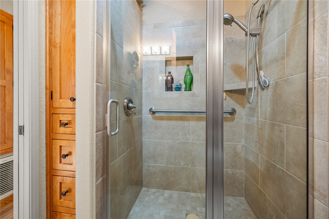 2000 Ramar Road, Unit 665 Bullhead City, AZ 86442 - Photo 28 of 83 Walk-in shower featuring tile surround, glass enclosure, built-in niche, and grab bar.