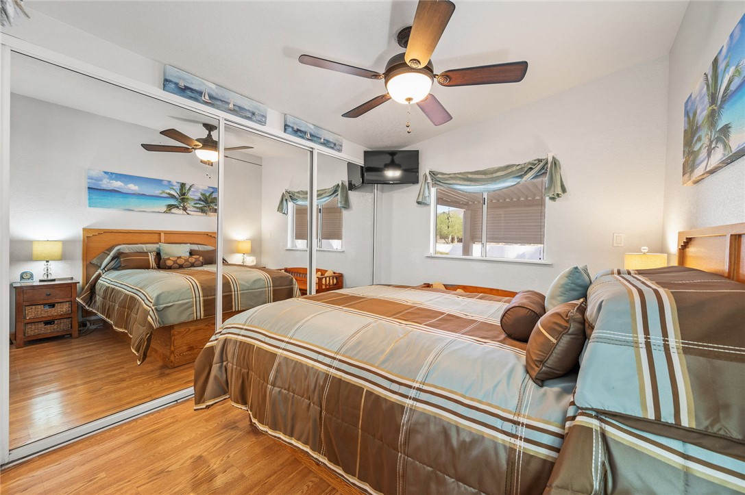 2000 Ramar Road, Unit 665 Bullhead City, AZ 86442 - Photo 29 of 83 Primary bedroom with luxury hard surface flooring, ceiling fan, mirrored closet doors, and ample space for bedroom furnishings.