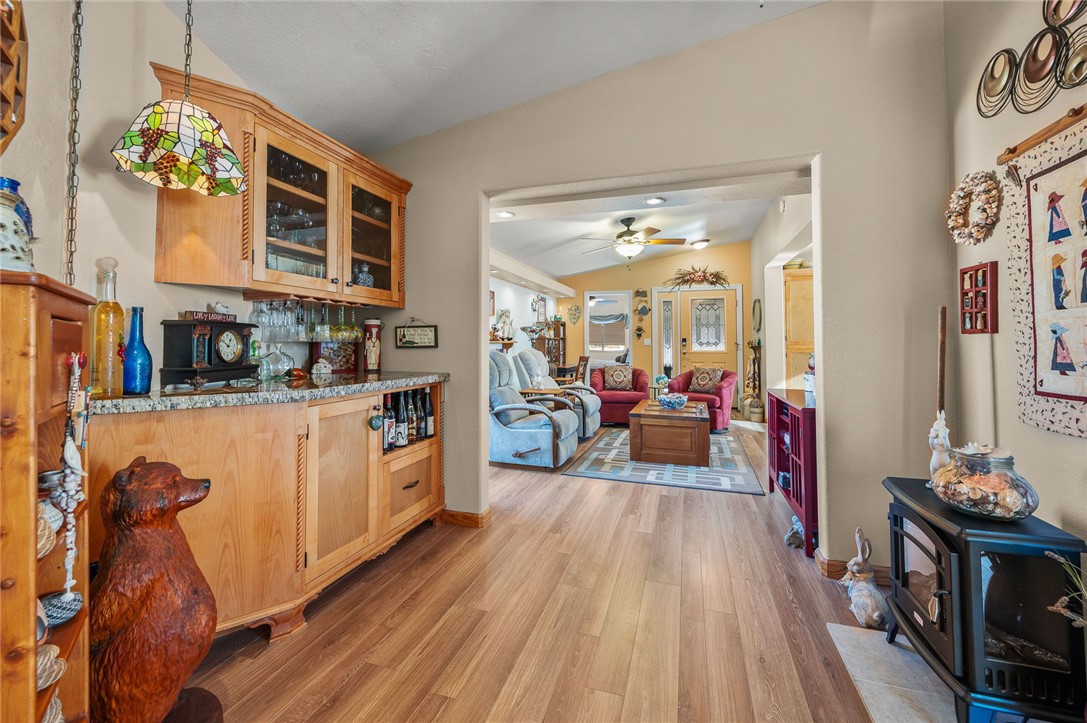 2000 Ramar Road, Unit 665 Bullhead City, AZ 86442 - Photo 35 of 83 Built-in bar area with custom wood cabinetry, granite countertop, glass-front upper cabinets, and luxury hard surface flooring.