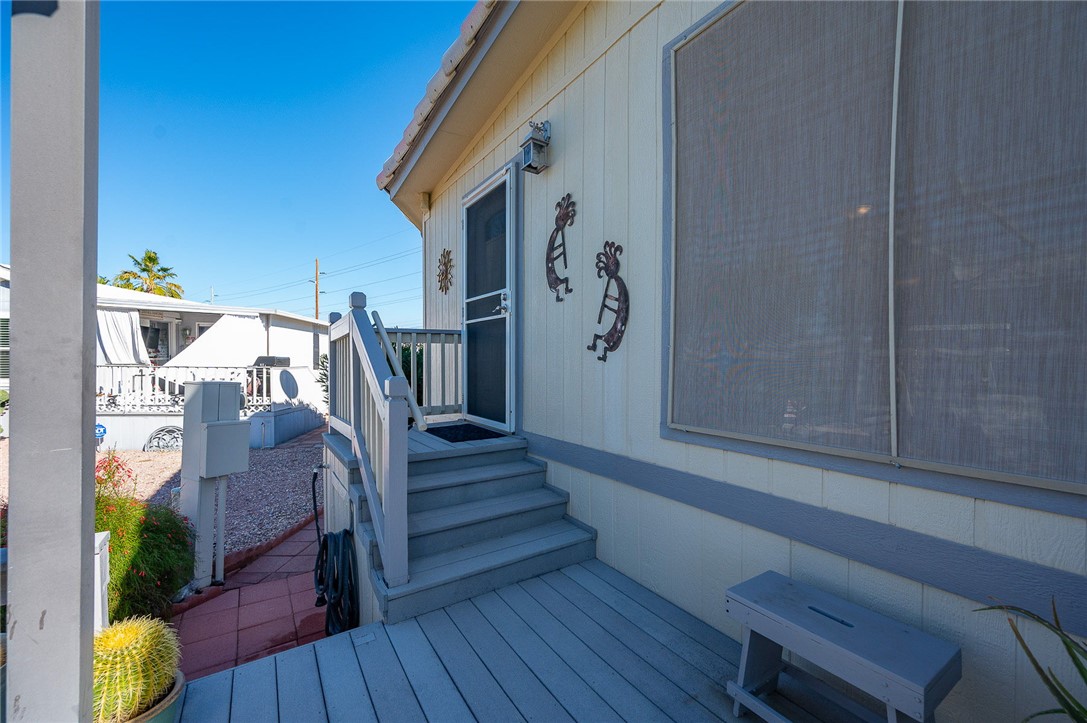 2000 Ramar Road, Unit 665 Bullhead City, AZ 86442 - Photo 42 of 83 Back entry with raised deck, handrail, and screened window, providing convenient secondary access to the home.