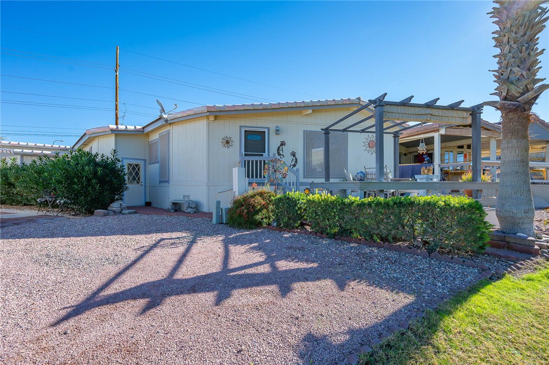 2000 Ramar Road, Unit 665 Bullhead City, AZ 86442 - Photo 51 of 83 Rear exterior with elevated deck, pergola, golf course frontage, and one of three on-site storage units (side access).