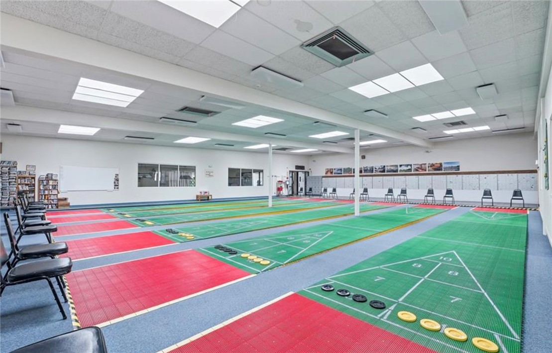 2000 Ramar Road, Unit 665 Bullhead City, AZ 86442 - Photo 71 of 83 Indoor shuffleboard facility featuring multiple regulation courts and ample seating.