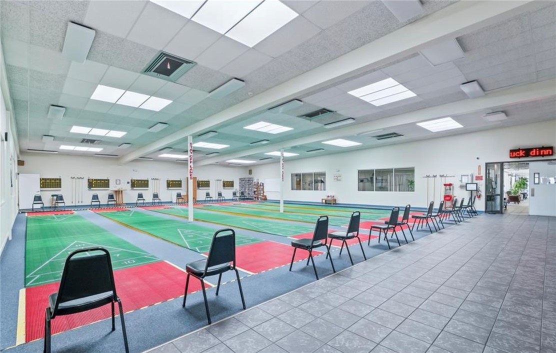 2000 Ramar Road, Unit 665 Bullhead City, AZ 86442 - Photo 72 of 83 Indoor shuffleboard facility featuring multiple regulation courts, climate-controlled comfort, and ample seating for year-round recreation.