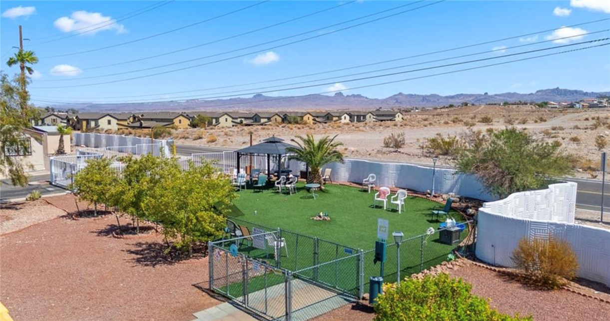 2000 Ramar Road, Unit 665 Bullhead City, AZ 86442 - Photo 78 of 83 Fenced community dog park featuring artificial turf, shaded seating, and a secure area for pets to play.