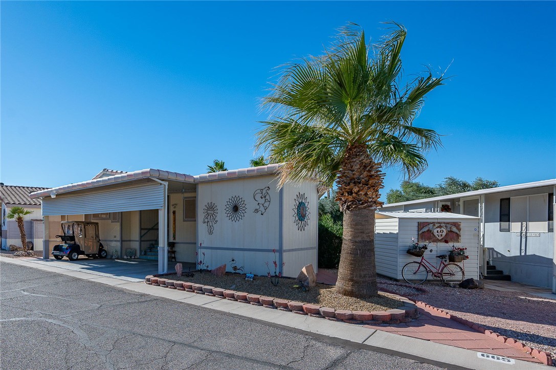 2000 Ramar Road, Unit 665 Bullhead City, AZ 86442 - Photo 8 of 83 Classic resort curb appeal framed by palms, covered parking and a huge shed large enough to park a golf cart in.