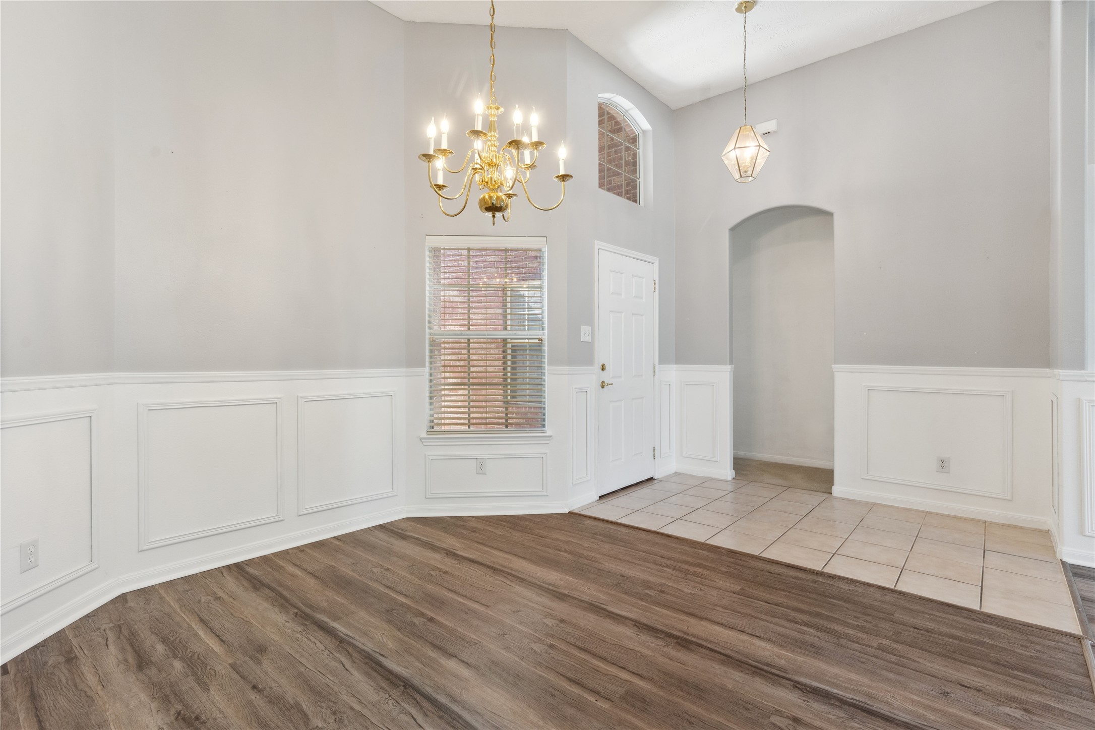 7906 Fortrose Court Houston, TX 77070 - Photo 12 of 28 an empty room with wooden floor chandelier and windows