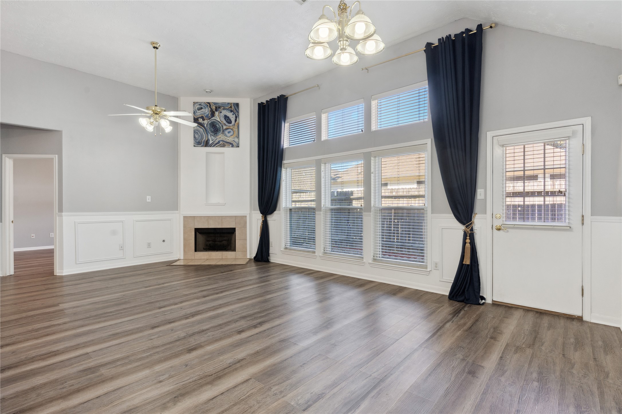 7906 Fortrose Court Houston, TX 77070 - Photo 9 of 28 a view of a livingroom with wooden floor a fireplace window a kitchen and chandelier