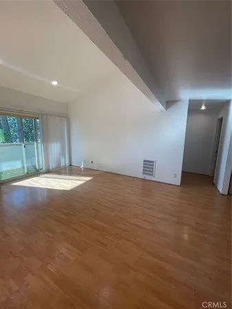 a view of big room with wooden floor and windows