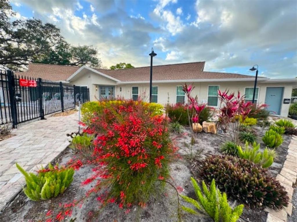946 Virginia Street, Unit 104 Dunedin, FL 34698 - Photo 28 of 64 a front view of a house with a yard and fountain in front of it