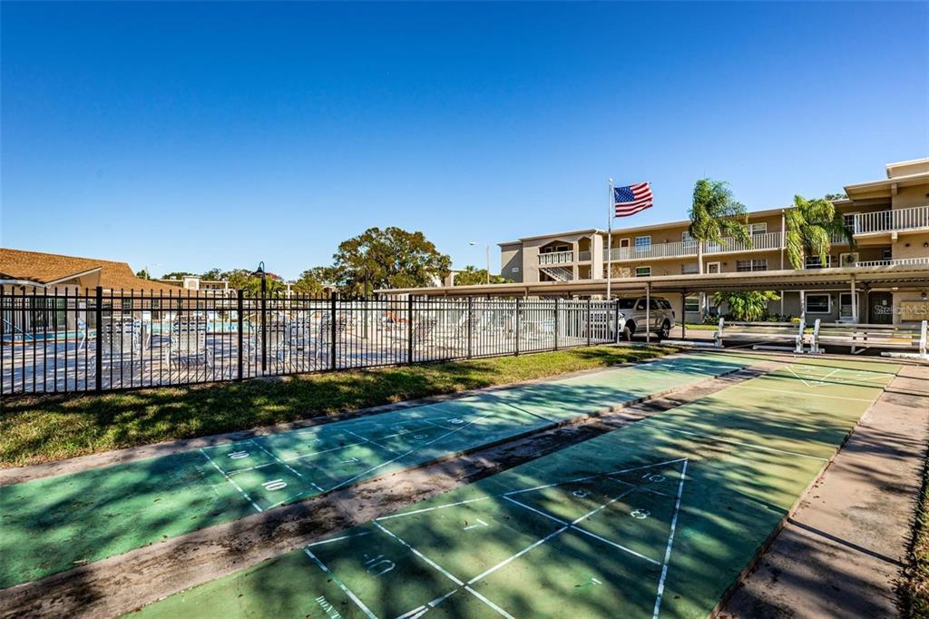 946 Virginia Street, Unit 104 Dunedin, FL 34698 - Photo 33 of 64 a view of a swimming pool with an outdoor seating and a garden