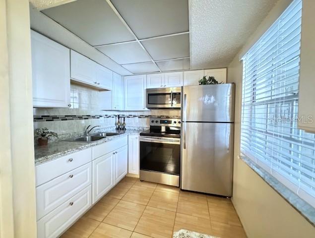 946 Virginia Street, Unit 104 Dunedin, FL 34698 - Photo 5 of 64 a kitchen with granite countertop a refrigerator and a stove top oven