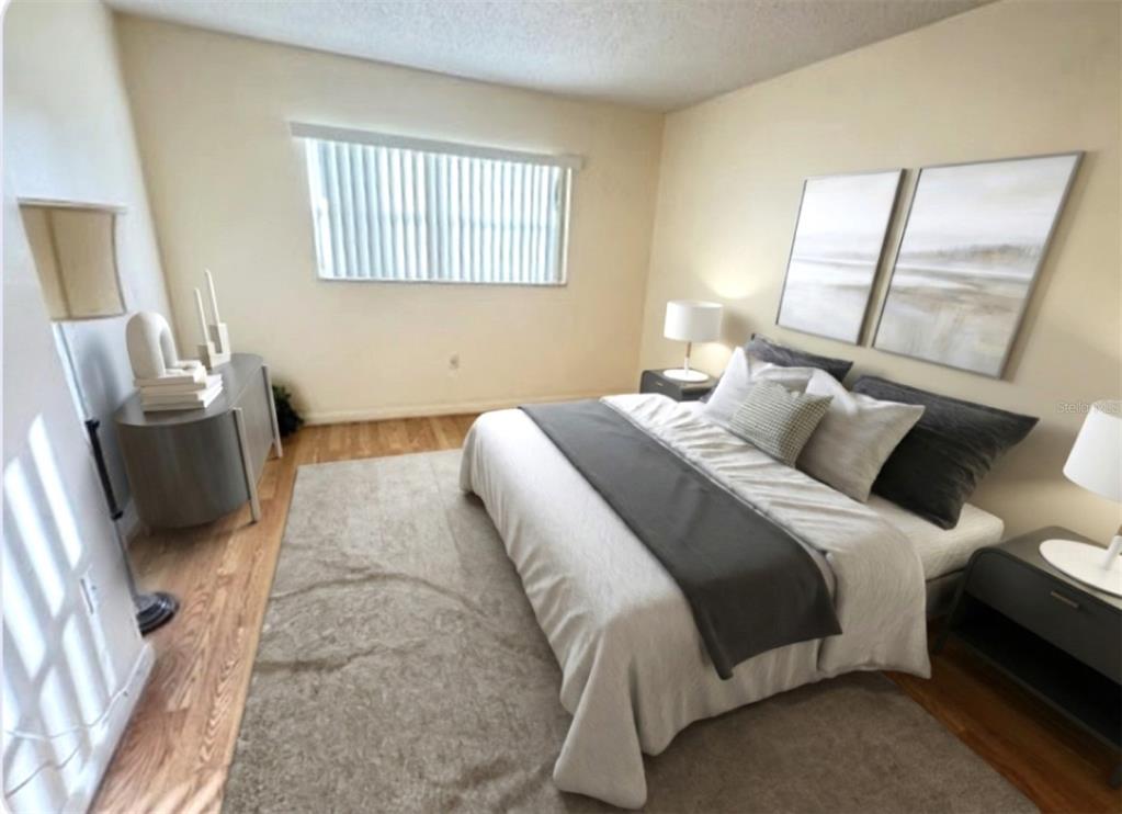 946 Virginia Street, Unit 104 Dunedin, FL 34698 - Photo 9 of 64 a bedroom with a bed and wooden floor