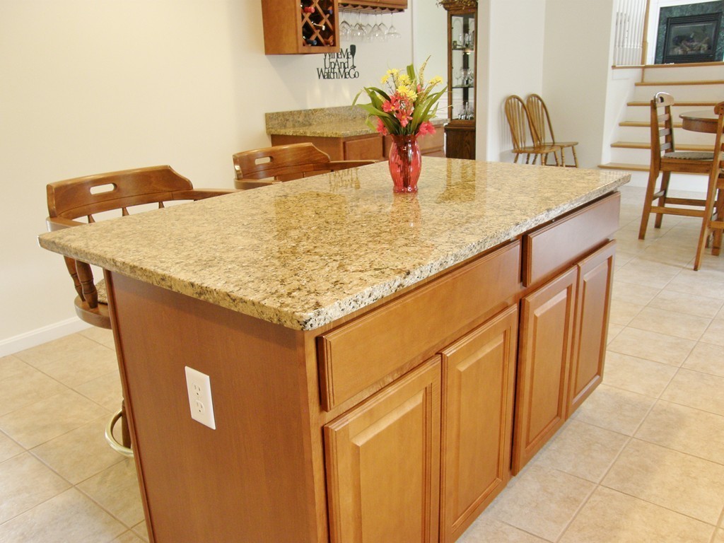 12 Tannery Road Sturbridge, MA 01518 - Photo 5 of 26 a kitchen with stainless steel appliances granite countertop a sink a refrigerator and wooden cabinets