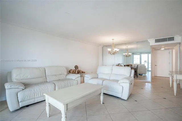 a living room with furniture and a dining table with kitchen view