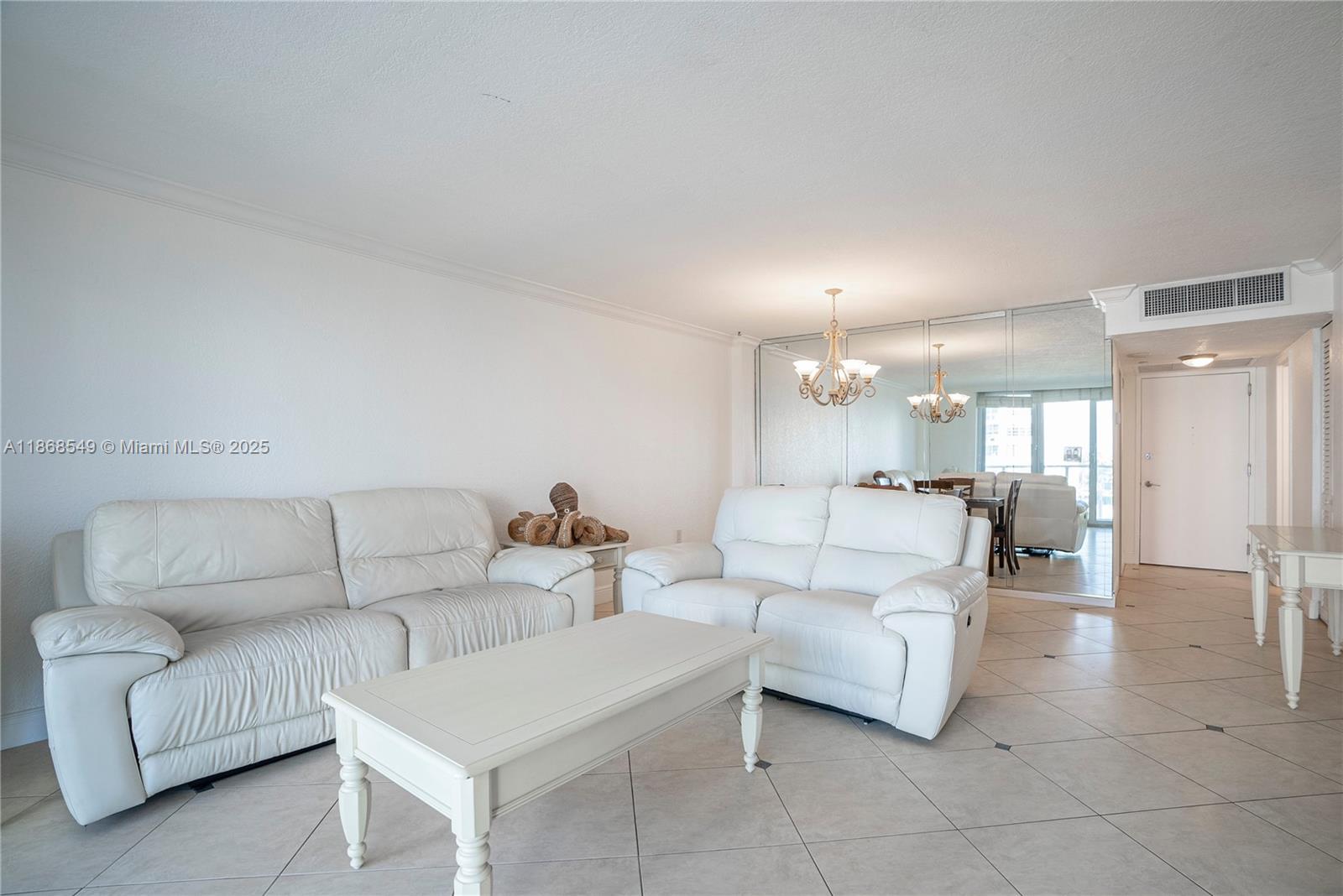 5701 Collins Avenue, Unit 405 Miami Beach, FL 33140 - Photo 3 of 18 a living room with furniture and a dining table with kitchen view