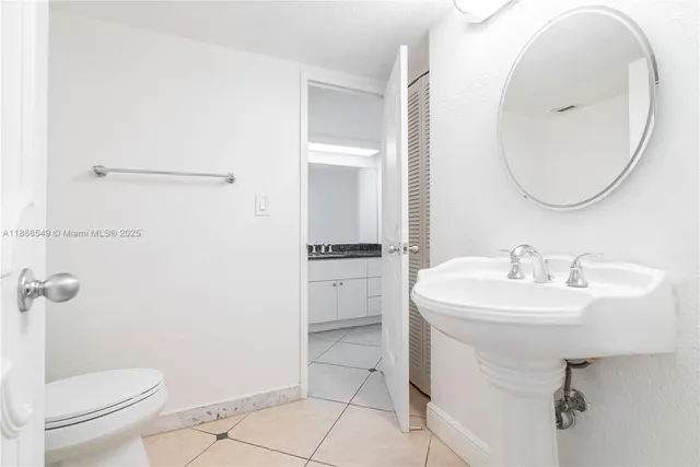 a bathroom with a sink toilet and a mirror