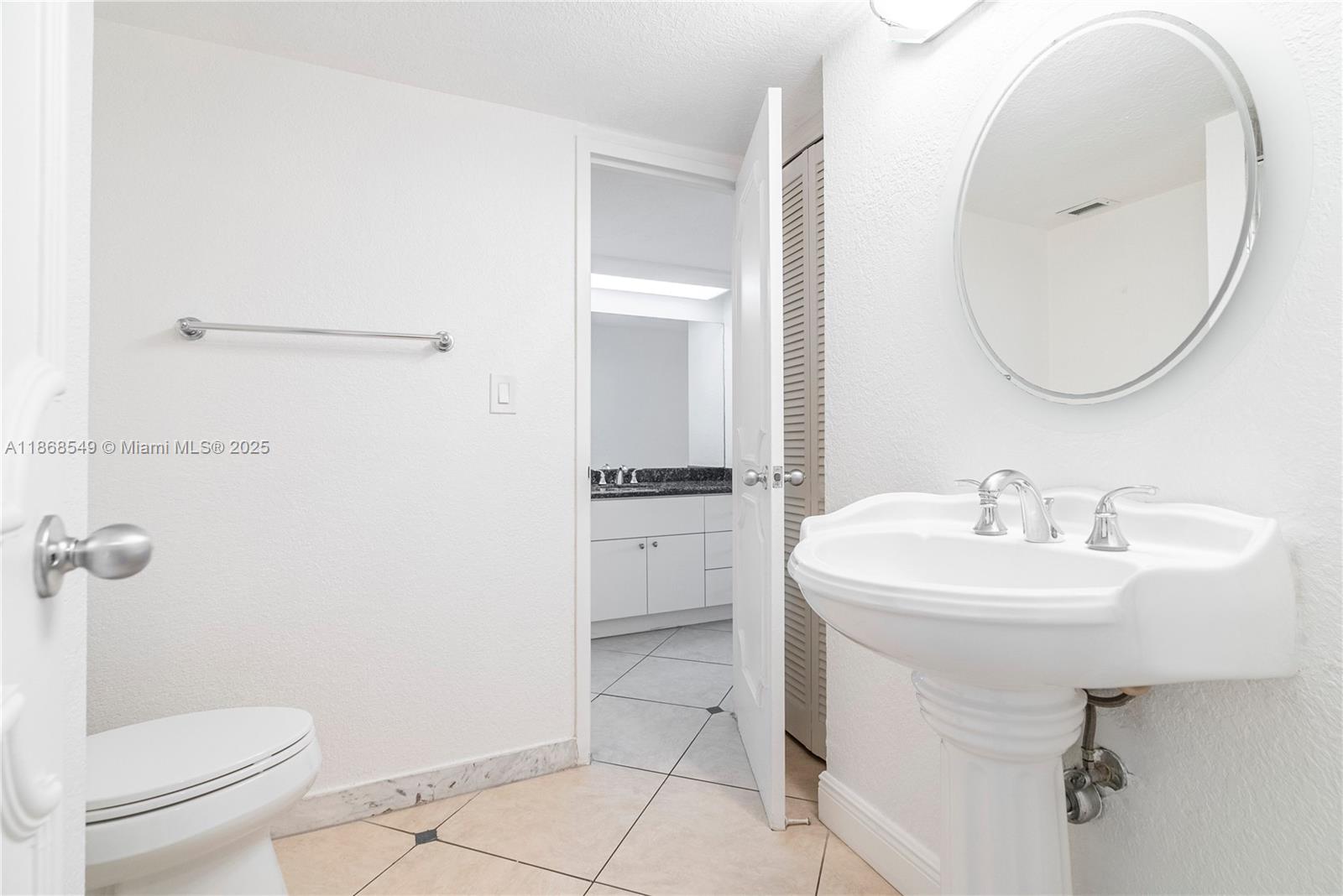 5701 Collins Avenue, Unit 405 Miami Beach, FL 33140 - Photo 10 of 18 a bathroom with a sink toilet and a mirror