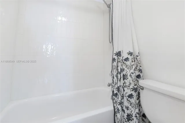 a bathroom with a bathtub and shower curtain