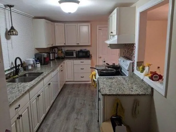 a kitchen with stainless steel appliances granite countertop a sink stove and cabinets