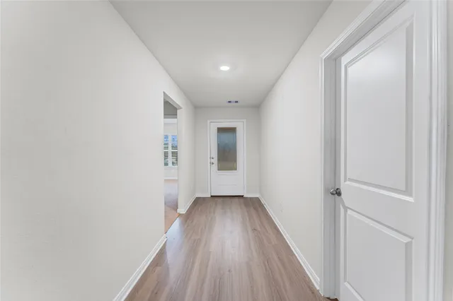 a view of a hallway with wooden floor