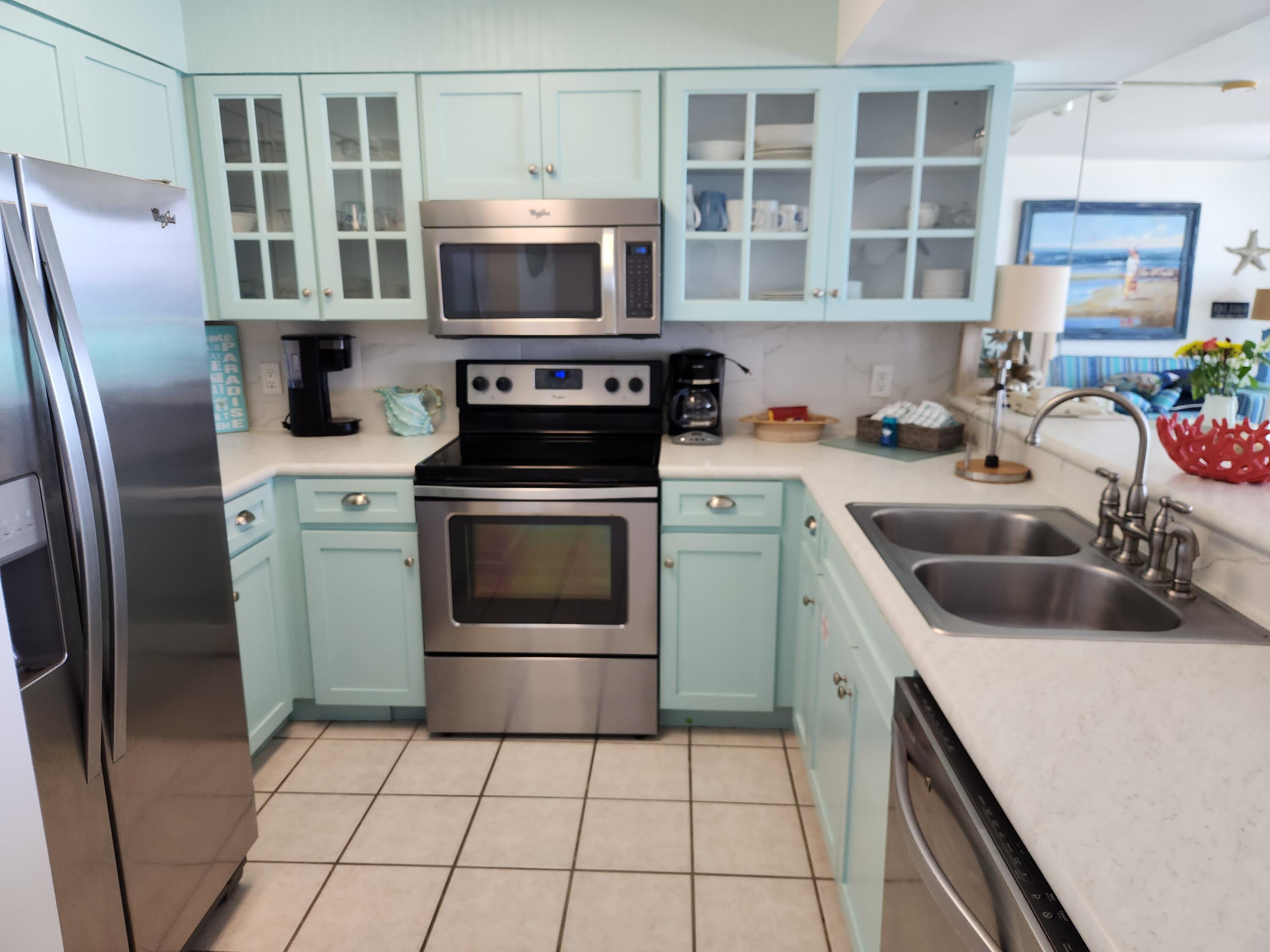 1002 Highway 98, Unit 505 Destin, FL 32541 - Photo 7 of 17 a kitchen with stainless steel appliances a stove a microwave and a sink