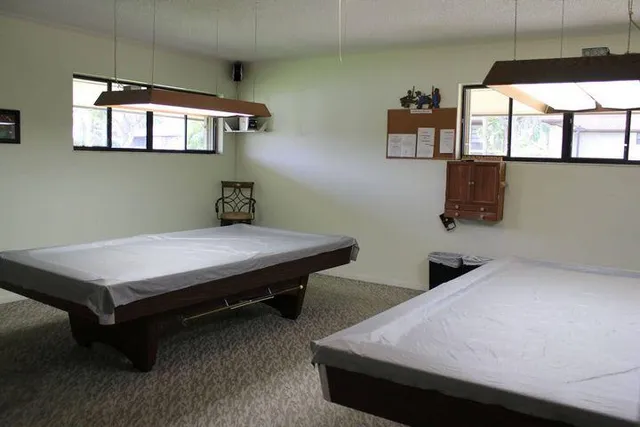 a room with pool table and windows