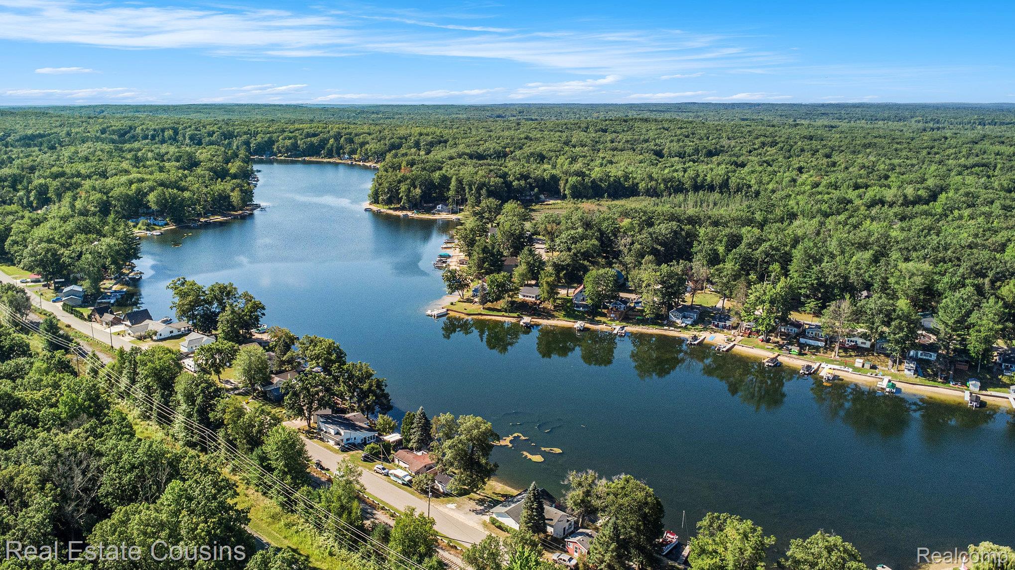1734 Forest Road Harrison, MI 48625 - Photo 27 of 31 Aerial view of property and surrounding area featuring a heavily wooded area and a large body of water