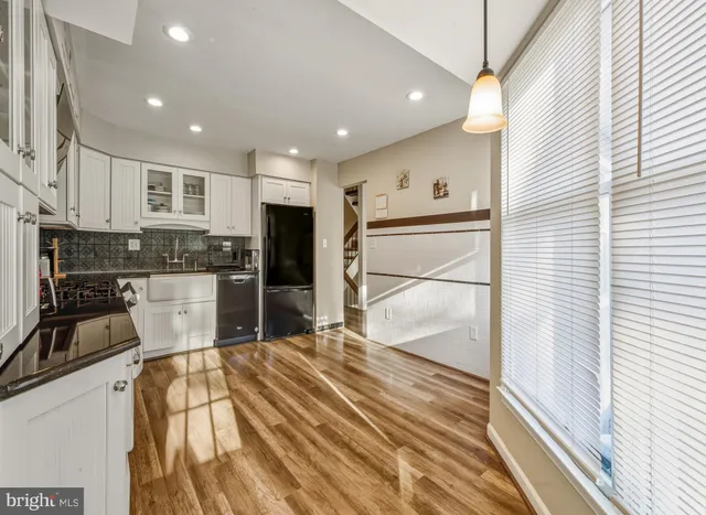 a kitchen with kitchen island a counter top space a sink stainless steel appliances and cabinets