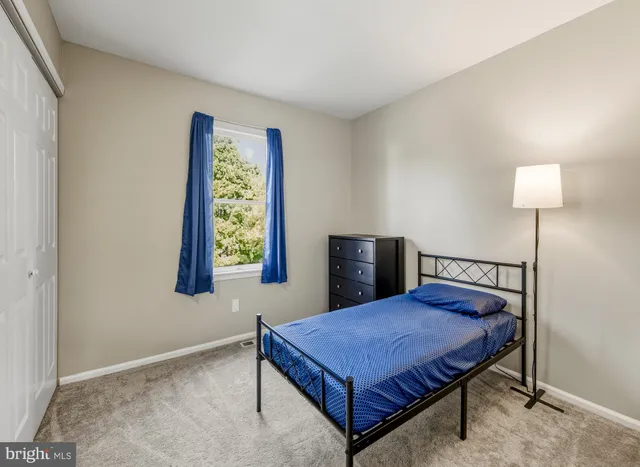 a bed sitting in a bedroom next to a lamp