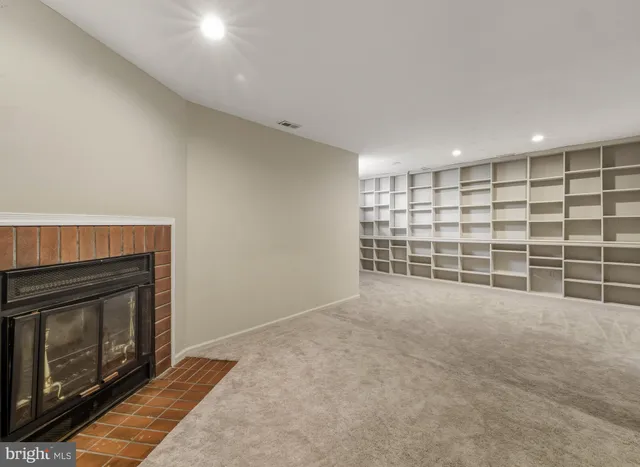 a view of an empty room with a fireplace and a window