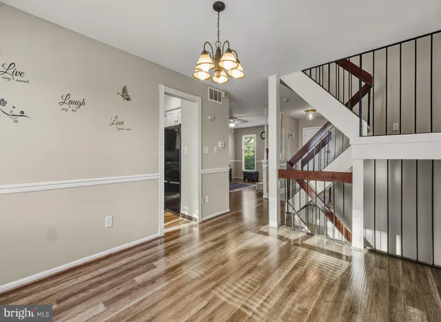 wooden floor in an empty room with a chandelier