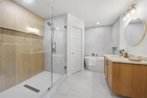 a spacious bathroom with a tub sink and mirror
