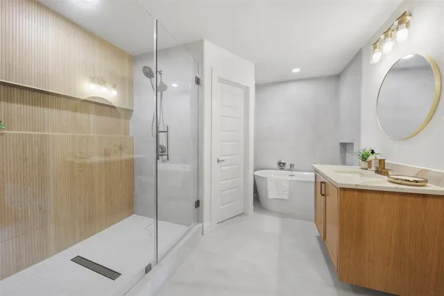 a spacious bathroom with a tub sink and mirror