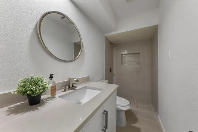 a bathroom with a granite countertop sink a toilet and a mirror