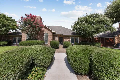 a view of a house with a yard and potted plants