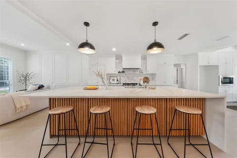 a kitchen with a table chairs in it and wooden floors