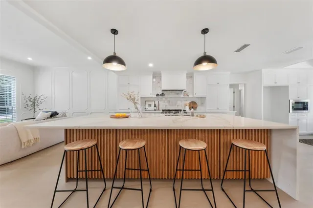 a kitchen with a table chairs in it and wooden floors