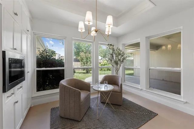 a living room with furniture a lamp a rug and a floor to ceiling window