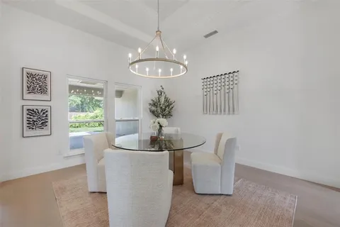 a dining room with chandelier and window
