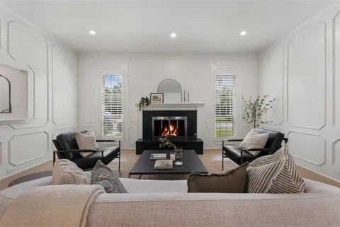 a living room with furniture a fireplace and a large window