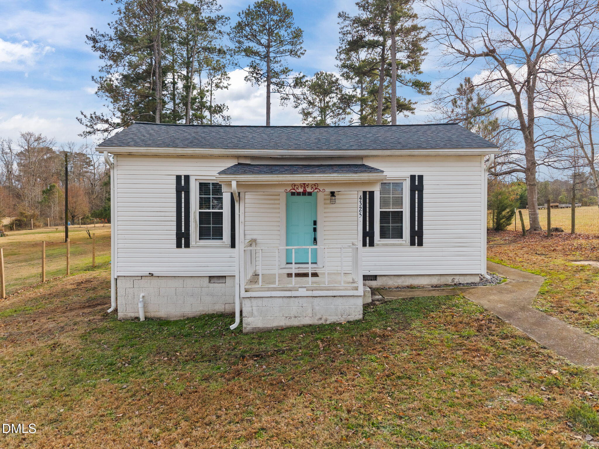a view of a white house with a large tree